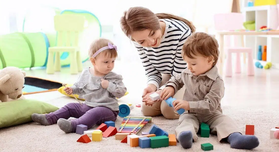 Une dame qui joue avec deux enfants